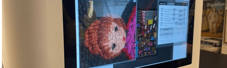 Una pantalla mostrando un software de digitalización y un par de cuadros de textiles.
